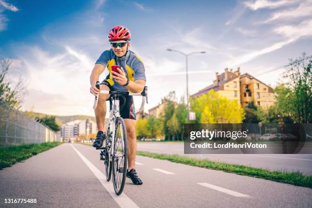 man using mobile phone on bicycle - biking athletic stock pictures, royalty-free photos & images