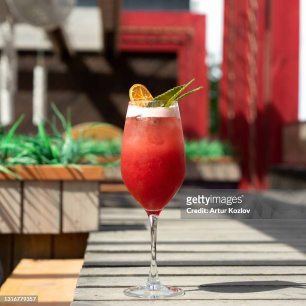 alcoholic drink. glass of red tropical cocktail against of sun terrace on blurred background. vacation concept - tequila tasting stock pictures, royalty-free photos & images