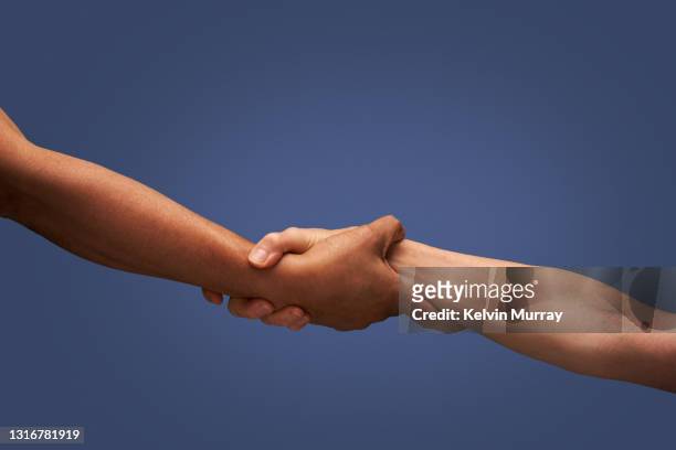 close up of holding hands - harmonie stockfoto's en -beelden