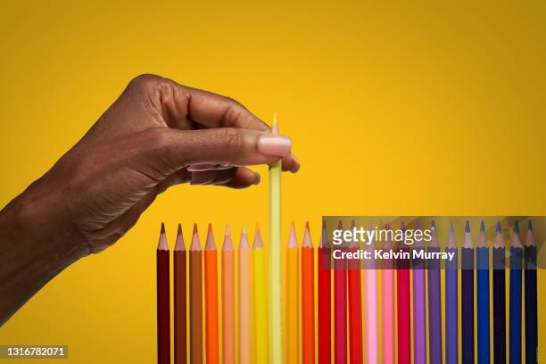 hand picking coloured pencil - yellow pencil stock pictures, royalty-free photos & images
