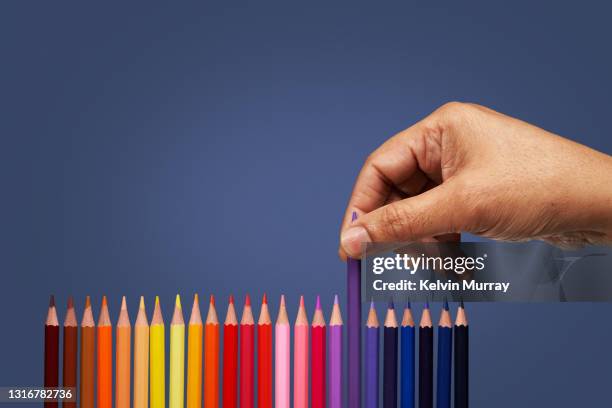 hand picking coloured pencil - elegir fotografías e imágenes de stock