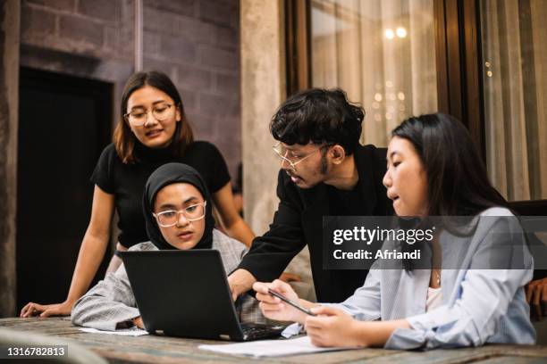 meeting of young professionals in a co-working space - zuidoost aziatische etniciteit stockfoto's en -beelden
