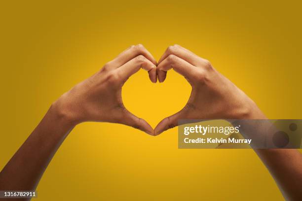 hands making heart shape - corazon fotografías e imágenes de stock