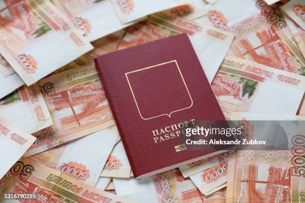 cash five thousand russian rubles in bills, on a white background or table. a bundle of banknotes, a russian passport. the concept of travel and vacation abroad. purchase of a ticket for an airplane flight. - russland stock-fotos und bilder