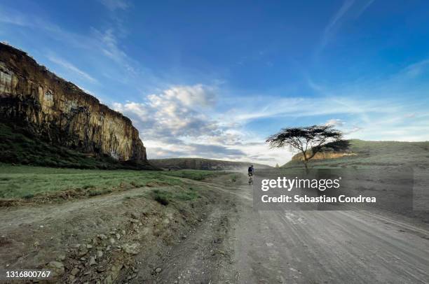 safari in hell's gate national park in kenya. off road bike, savannah and mountain view. explore wilderness of africa. - kenya road stock pictures, royalty-free photos & images