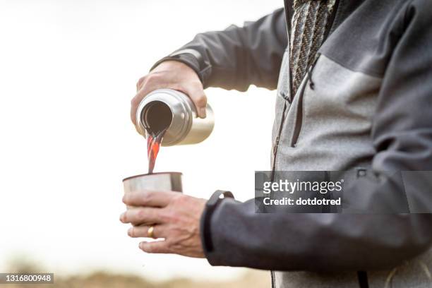uk, london, epping forest, close-up of man pouring coffee from thermos - flask stock pictures, royalty-free photos & images