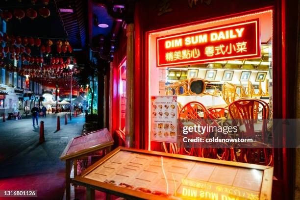 dim sum chinese restaurant illuminated at night in chinatown, london, uk - dimsum stock pictures, royalty-free photos & images