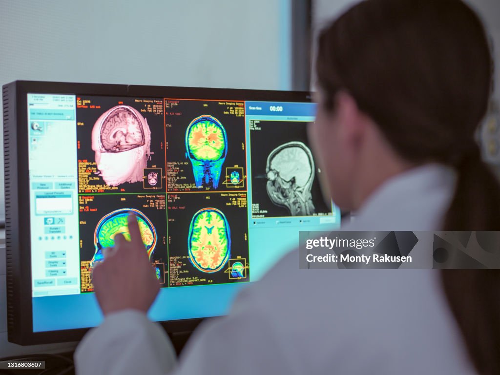 UK, North Yorkshire, Female doctor looking at MRI scanner monitor