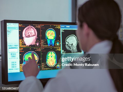 UK, North Yorkshire, Female doctor looking at MRI scanner monitor UK, North Yorkshire, Female doctor looking at MRI scanner monitor