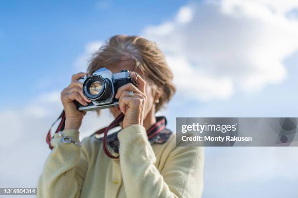 uk, north yorkshire, woman with camera against sky - fotografieren stock-fotos und bilder