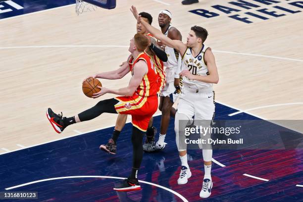 Kevin Huerter of the Atlanta Hawks attempts a shot while being guarded by Doug McDermott of the Indiana Pacers in the third quarter at Bankers Life...