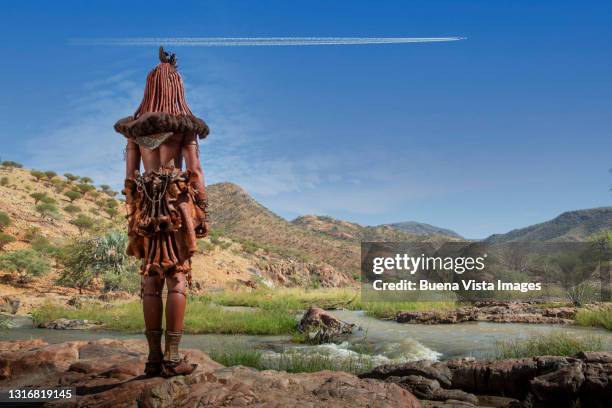 himba woman watching a flying airplane - namibia airplane stock pictures, royalty-free photos & images