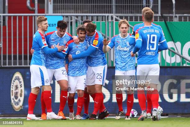 Fin Bartels of Holstein Kiel celebrates with team mates Janni Serra, Phil Neumann and Finn Porath after scoring his team's second goal during the...