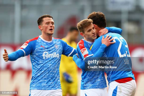 Janni Serra of Holstein Kiel celebrates with team mates Fabian Reese and Niklas Hauptmann after scoring his team's fourth goal during the Second...