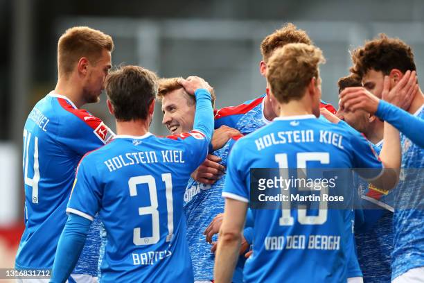 Janni Serra of Holstein Kiel celebrates with team mates Niklas Hauptmann, Hauke Wahl and Fin Bartels after scoring his team's fourth goal during the...
