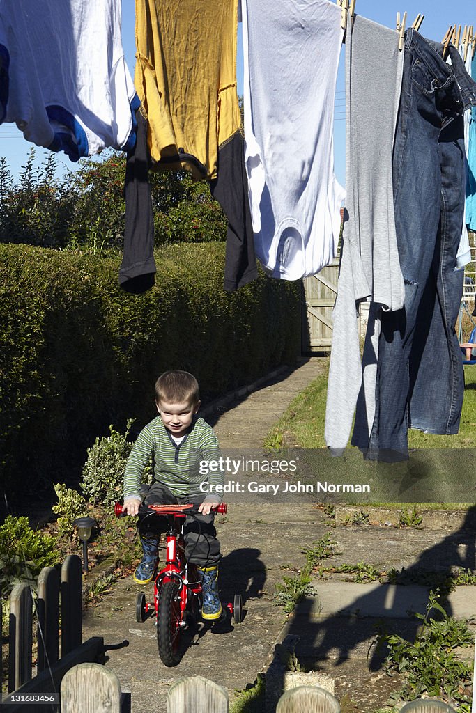 Young boy on new bike in garden