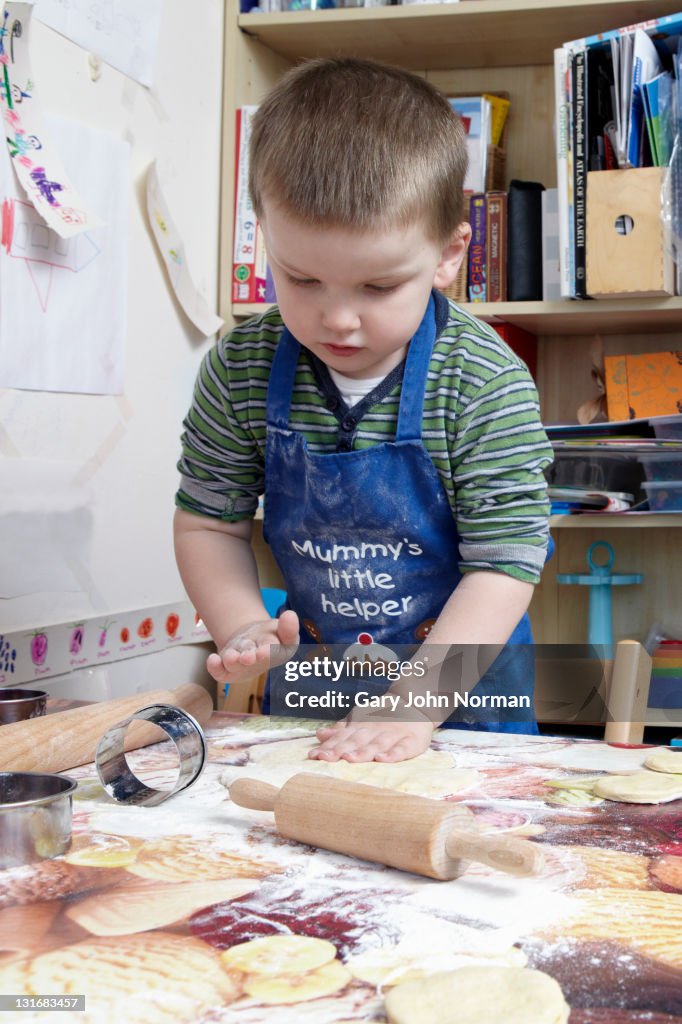 Young boy playing with pastry dough.