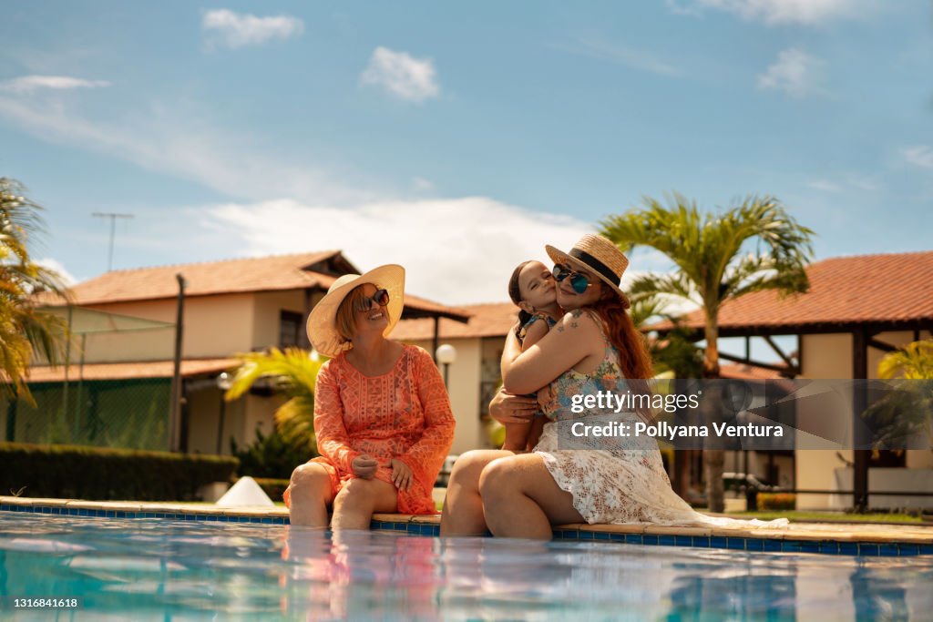 Family by the pool hugging the child