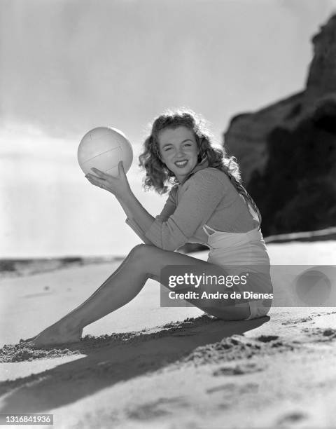 Portrait of American actress and model Marilyn Monroe as she poses with volleyball at Zuma Beach's Paradise Cove, California, 1945.