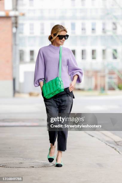 Influencer Gitta Banko wearing a lavender colored knitted pullover with balloon sleeves by T7, slouchy washed out black denim jeans pants by Nili...