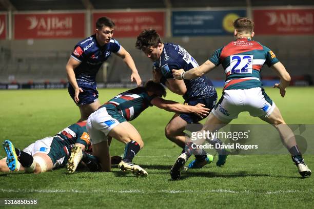 Tom Curry of Sale is held up by David Williams and Jack Van Poortvliet of Leicester during the Gallagher Premiership Rugby match between Sale Sharks...