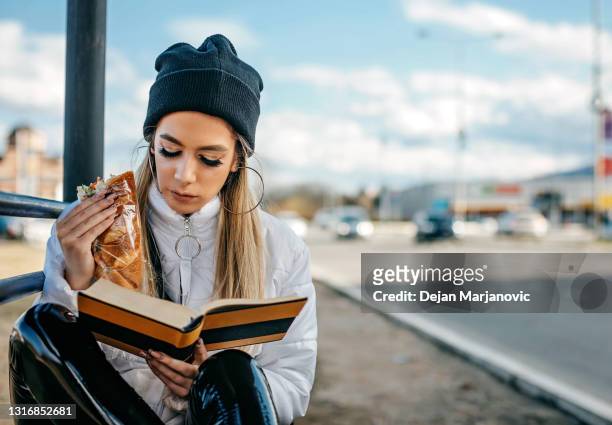 väntar på buss - read book outside young woman bildbanksfoton och bilder