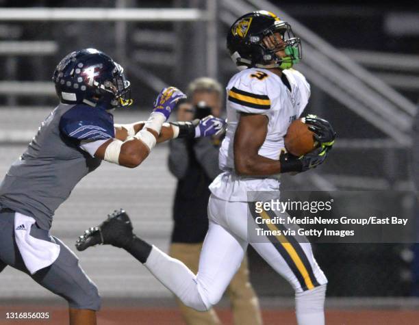Freedom High School player tries to get a hand on Bishop O'Dowd's Jevon Holland as Holland catches a pass and runs it in for a touchdown in the first...