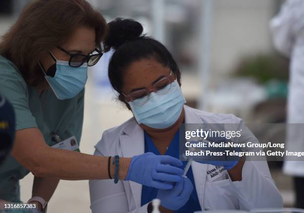 Nurse pracitioners Patricia Dahlberg, and Alyssa Flores Rios prepare a syringe during the SoCalGas"u2019 Fueling Our Communities Event to provide...