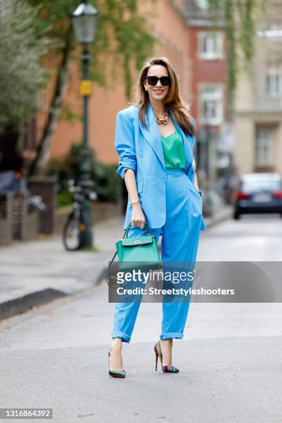Influencer Alexandra Lapp, wearing a blue suit by Aggi, a green Jadicted silk top, multicolored So Kate heels by Christian Louboutin, a gold and...