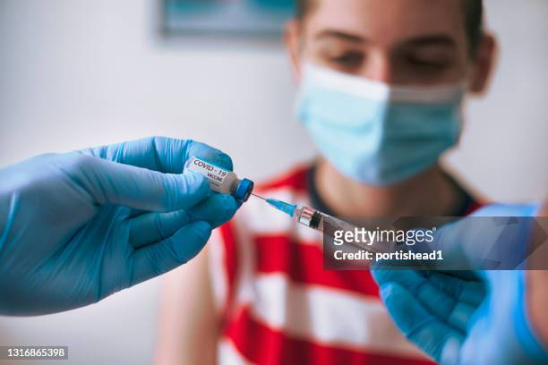 doctor vaccinating a teenage boy - injecting pen stock pictures, royalty-free photos & images