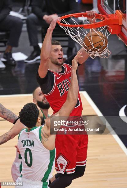 Zach LaVine of the Chicago Bulls dunks over Jayson Tatum and Evan Fournier of the Boston Celtics at the United Center on May 07, 2021 in Chicago,...
