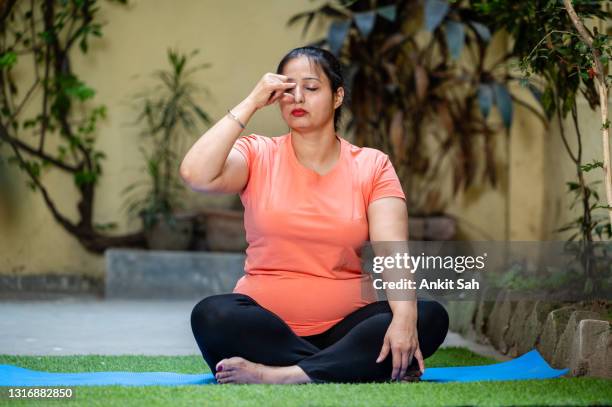 woman doing anulom vilom (yoga posture). inhaling and exhaling practice or breathing exercise. - pranayama stock pictures, royalty-free photos & images