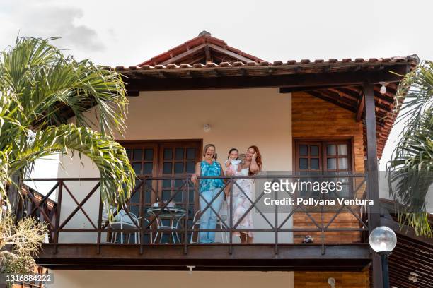 familia feliz en el balcón - beach house balcony fotografías e imágenes de stock