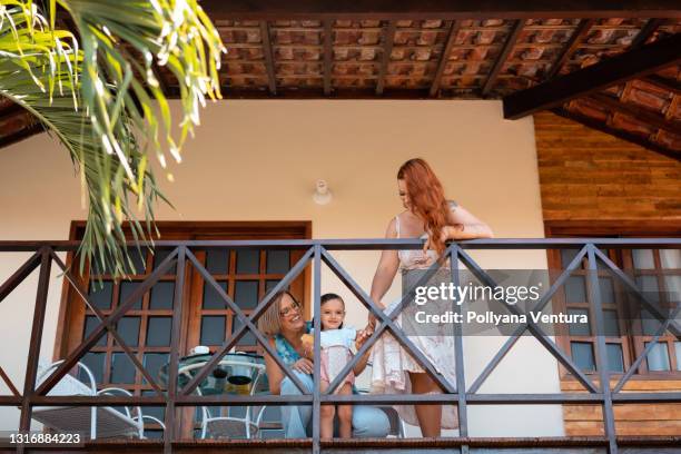 family on the balcony - beach house balcony stock pictures, royalty-free photos & images