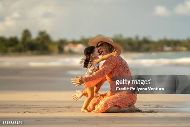 奶奶在海灘上擁抱她的孫女 - 孫娘 個照片及圖片檔