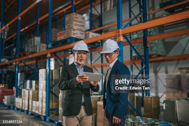 asian chinese management having discussion at warehouse with white hardhat using digital tablet - suit rack stock pictures, royalty-free photos & images