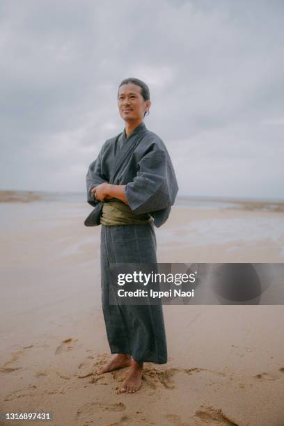 man in kimono standing on beach, japan - yukata stock pictures, royalty-free photos & images