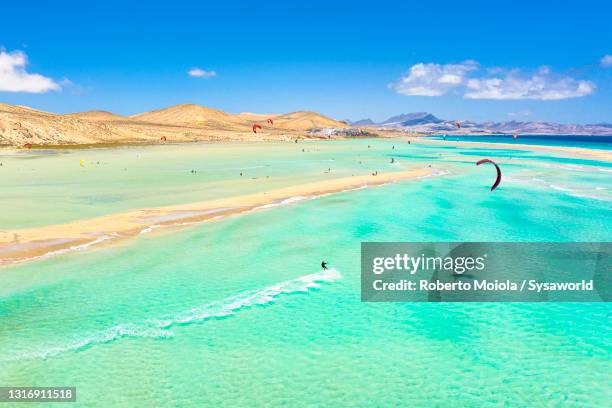 kiteboarding in the turquouise sea, fuerteventura - kite lagoon stock pictures, royalty-free photos & images