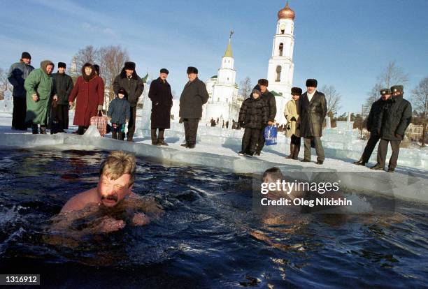 Russian men bathe in ice-cold water as others pray to mark the Russian Orthodox Epiphany January 19, 2001 near Raifa man''s monastery in Raifa,...