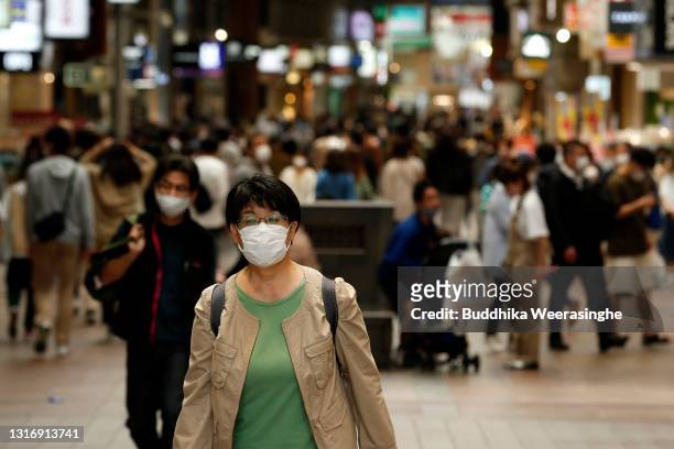 Woman wearing a protective face mask walks along a shopping street on May 08, 2021 in Kobe, Japan. Prime Minister Yoshihide Suga announced yesterday...