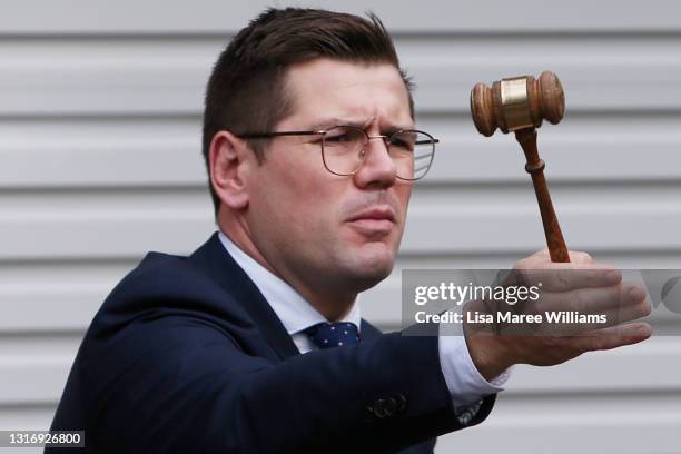 Auctioneer Jesse Davidson counts down a bid during an auction of a residential property in the suburb of Strathfield on May 08, 2021 in Sydney,...