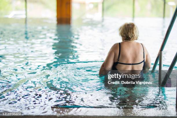 older woman entering the swimming pool - fat woman back stock pictures, royalty-free photos & images