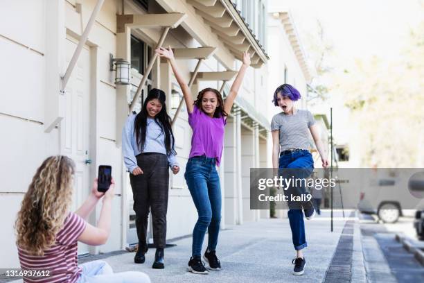 chica preadolescente filmando amigos con teléfono inteligente - purple hair fotografías e imágenes de stock
