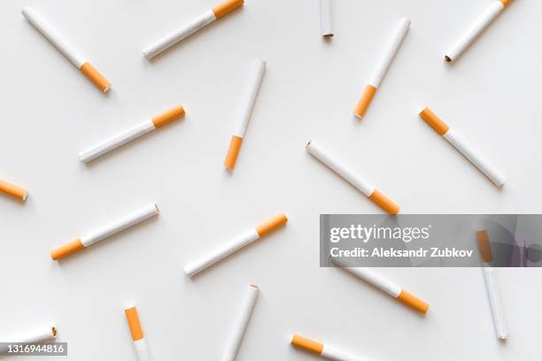 a stack of cigarettes on a white background. the concept of dependence on smoking, unhealthy lifestyle, harmful habits. - cigarette photos et images de collection