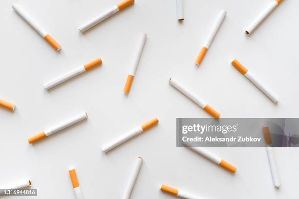 a stack of cigarettes on a white background. the concept of dependence on smoking, unhealthy lifestyle, harmful habits. - cigarette smoking stockfoto's en -beelden