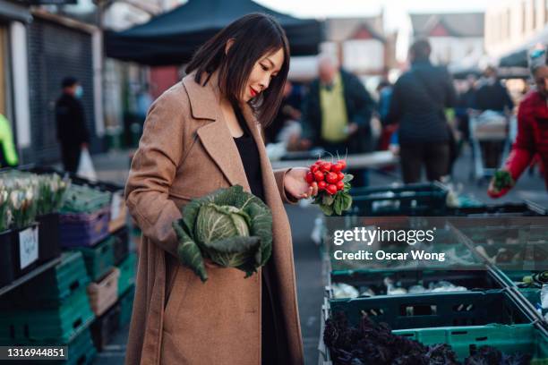 woman shopping for fresh organic vegetables at farmer market - kohlpflanze stock-fotos und bilder