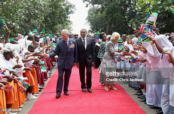 Camilla, Duchess of Cornwall, Prince Charles, Prince of Wales and President Jakaya Kikwete of Tanzania greet school children waving flags as they...