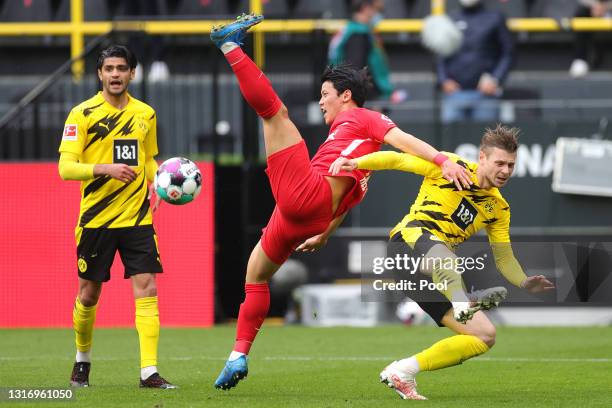 Hee-Chan Hwang of RB Leipzig is challenged by Lukasz Piszczek of Borussia Dortmund during the Bundesliga match between Borussia Dortmund and RB...