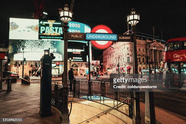 eingang der londoner u-bahnstation nachts im piccadilly circus, london, uk - picadilly lights stock-fotos und bilder