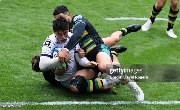 Louis Rees-Zammit of Gloucester dives over to score his second try despite being held by Matt Proctor and George Furbank during the Gallagher...